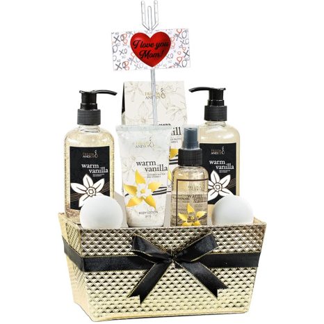 A gold gift basket contains warm vanilla-scented bath products, including lotions and gels, two bath bombs, and a black ribbon. A "I Love You Mom" card with a red heart is attached.