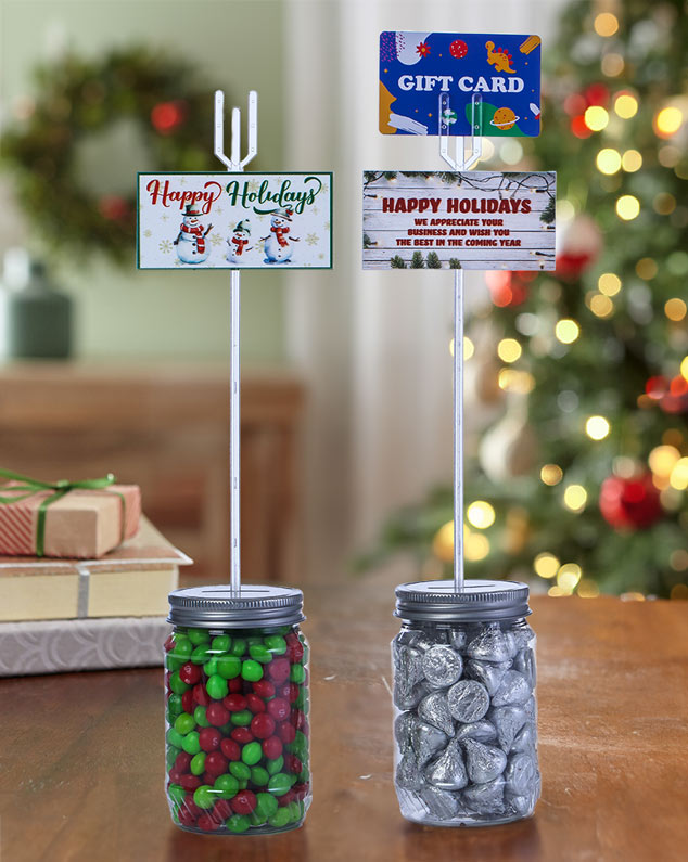 two jars of candy with a decorative holdiay pick in them.  The first pick say Happy Holidays and has cute snowmen. The second one says Happy Holidays. We appreciate your business and wish you the best in the coming year